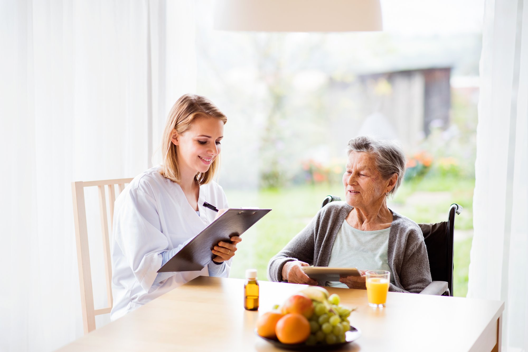 health-visitor-and-a-senior-woman-with-tablet-2024-10-18-08-55-12-utc