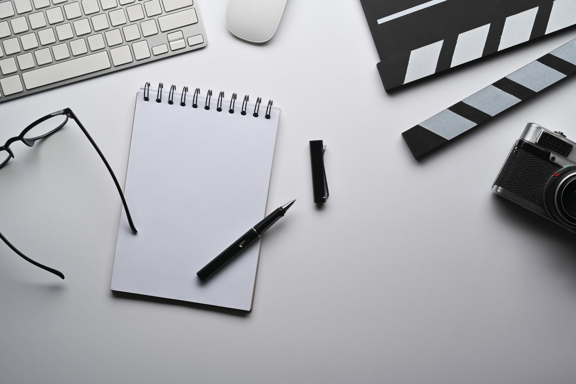 top-view-notebook-camera-and-clapperboard-on-whit-2023-11-27-05-34-57-utc