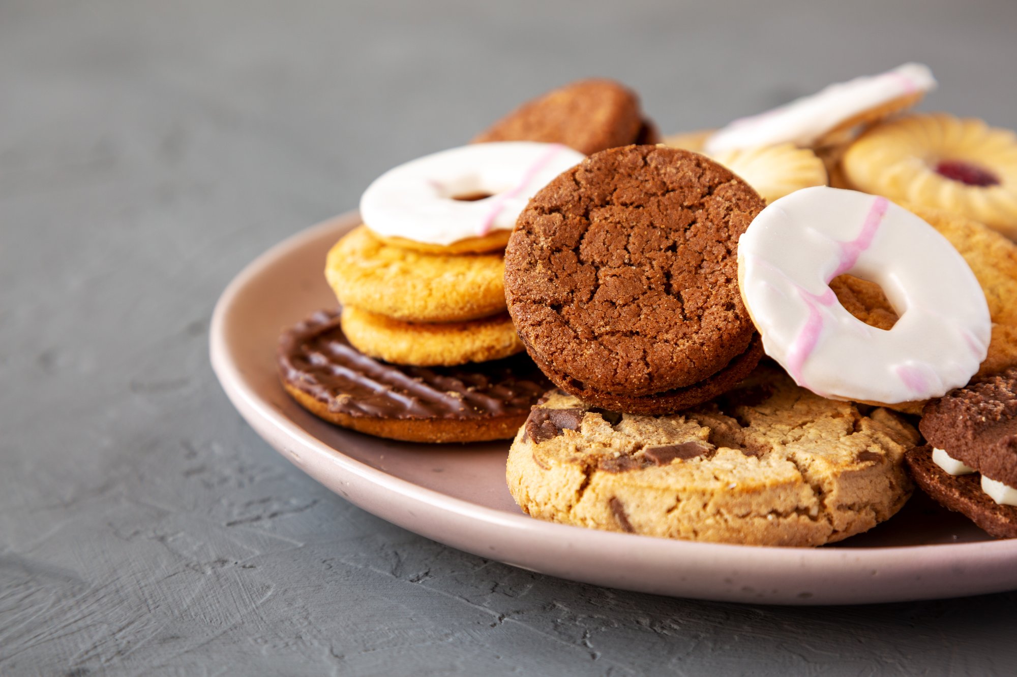 variety-of-biscuits-on-a-pink-plate-low-angle-vie-2024-10-18-09-09-42-utc