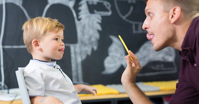 Alumno aprendiendo de un maestro a decir una palabra