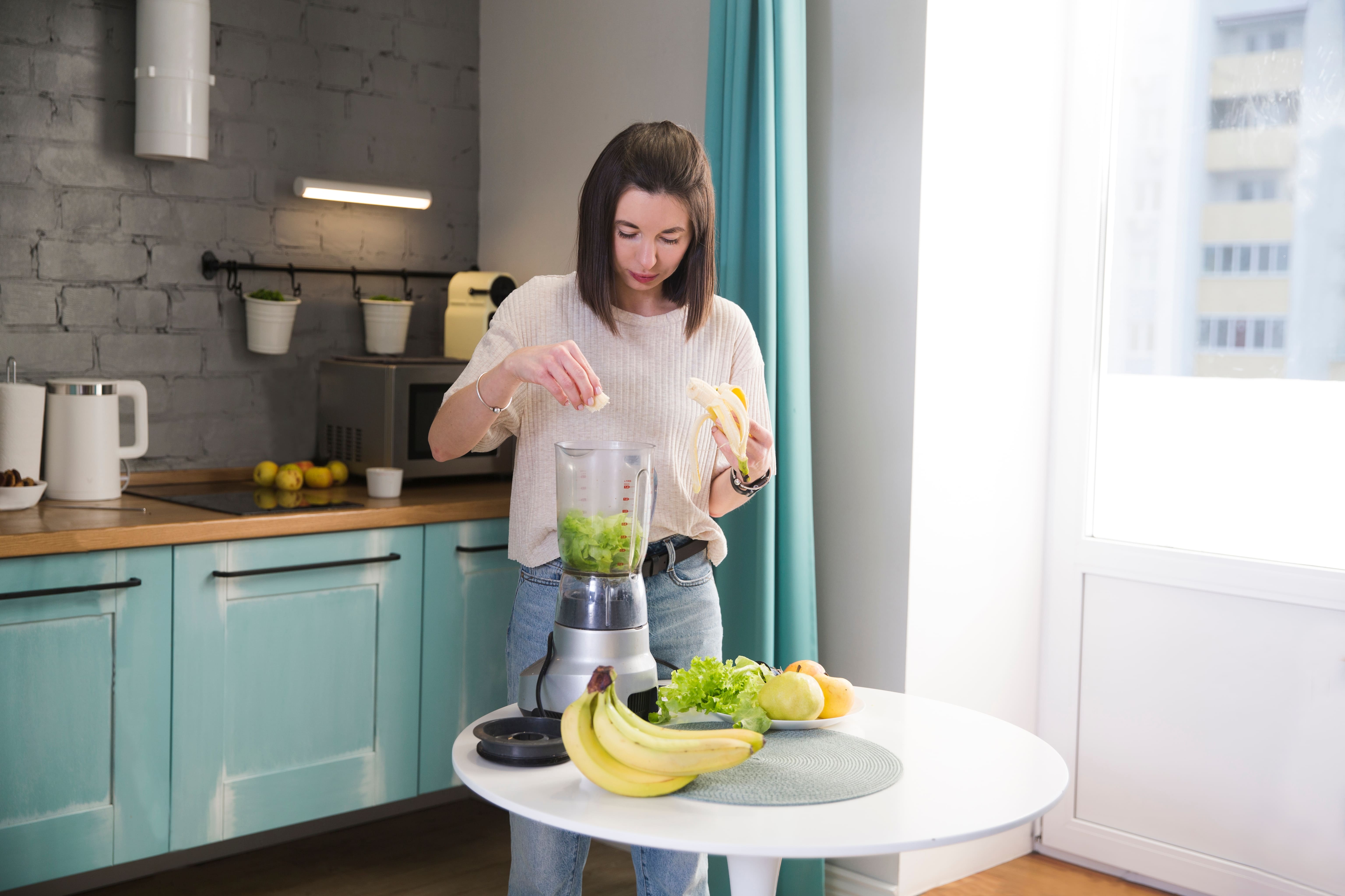 Chica licuando una comida saludable en su cocina 