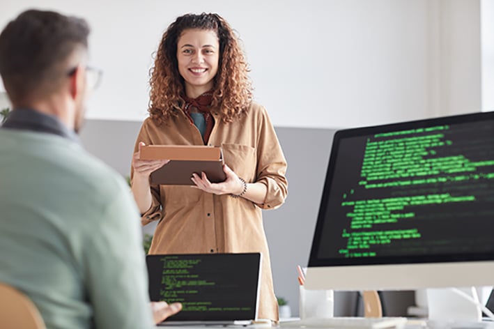 Persona enfrente de estudiante que enseña programación