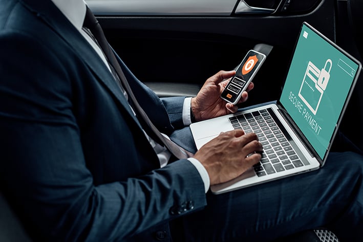 persona en su computadora realizando un pago seguro mientras esta en su coche