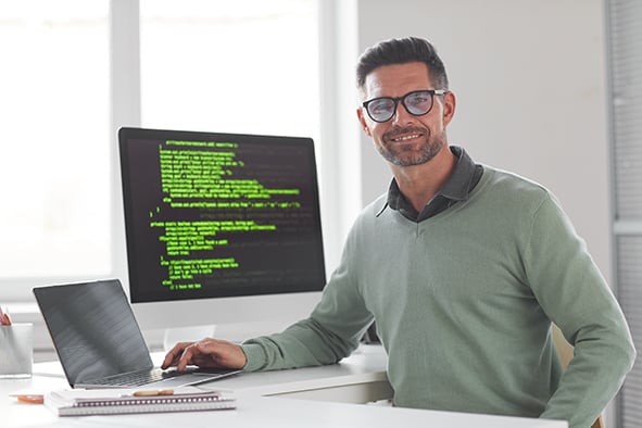 programador en su oficina con su computadora y laptop en un escritorio  