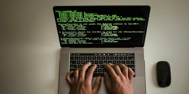 manos escribiendo codigo de programacion web en una computadora