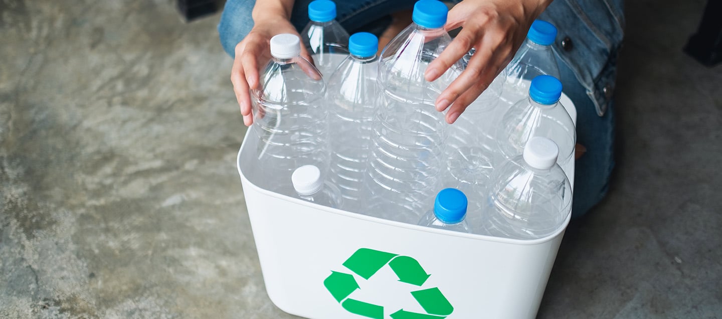 Persona realizando reciclaje de botellas de plástico