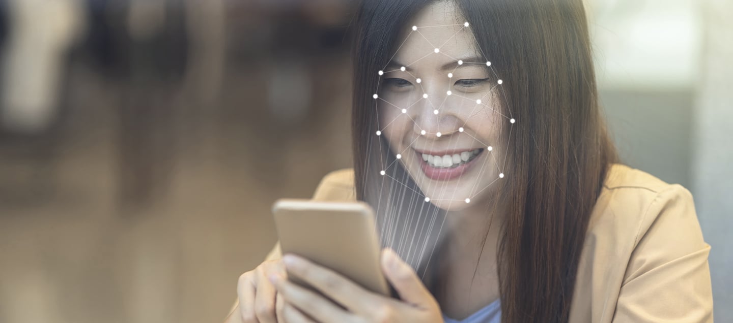Joven mujer utiliza su smartphone con reconocimiento facial
