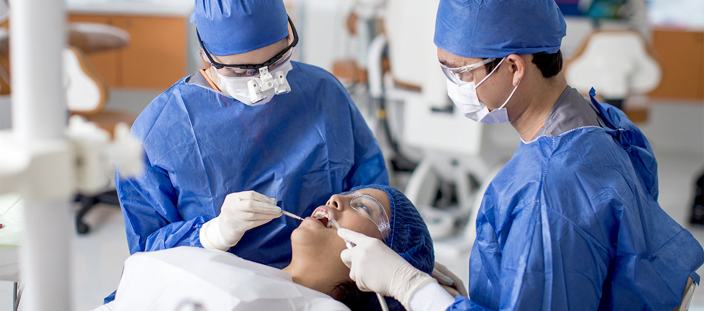 Estudiantes de odontología en práctica con un paciente